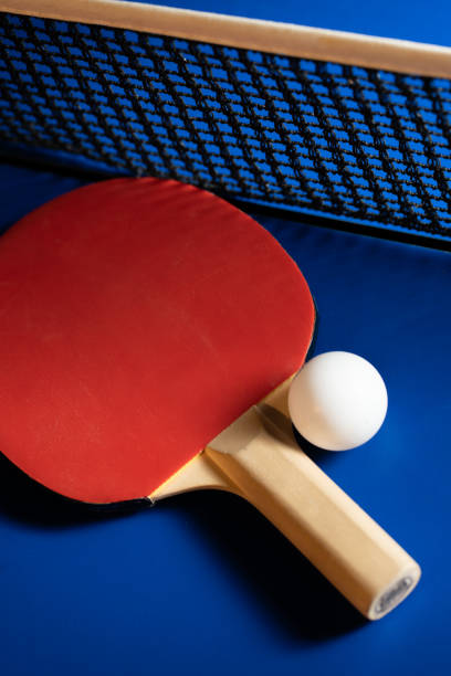 istock Ping pong rackets and balls on a blue table with net. 2199933132