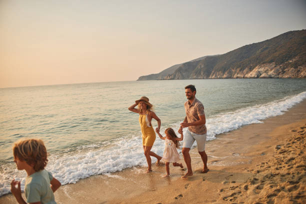 istock A family run hand in hand down a tropical paradise beach during sunset 2199934373