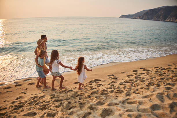 istock A family walks hand in hand down a tropical paradise beach during sunset 2199935140