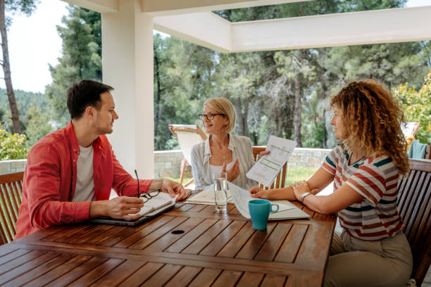 istock Colleagues discussing work at the back yard of house, working together 2199935910