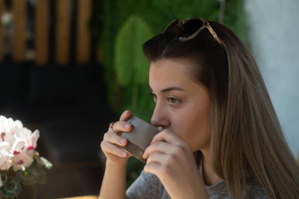 istock Woman drinking coffee in a cafe 2199936038