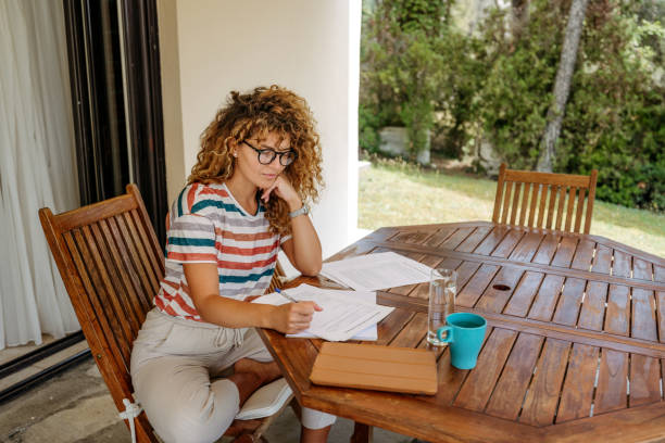 istock Beautiful young businesswoman analysing documents while working from home 2199936193