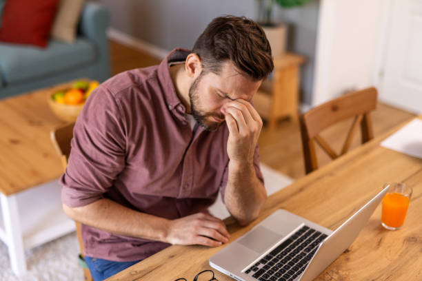 istock Businessman office working holding sore head pain from desk working and sitting all day using laptop computer or notebook suffering headache sick worker overworking concept 2199938335