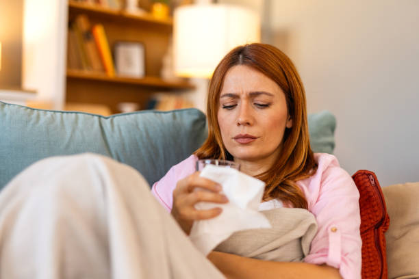 istock Sickness, seasonal virus problem concept. Woman being sick having flu lying on sofa. Sick woman lying in bed with high fever. Cold flu and migraine. 2199939062