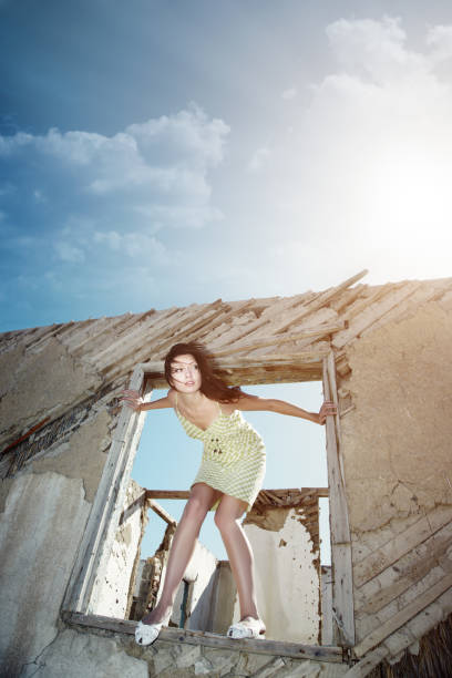 Young lady getting out the window of the old building