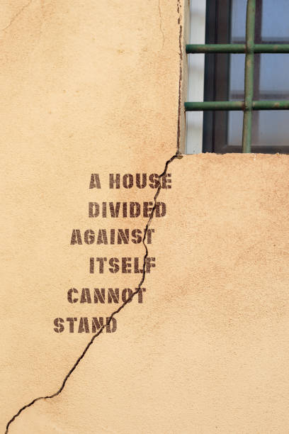 istock Cracked Wall with Divisive Quote and Barred Window 2199941741