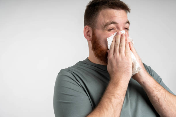 istock Sick unhealthy ill bearded man having runny nose, using napkin, having flu symptoms. 2199944255