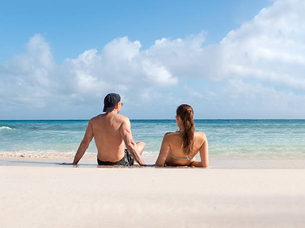 istock Handsome man cute woman and white sand beach 2199946117