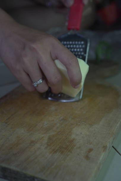 istock Cheese with a box grater over a wooden board 2199950692