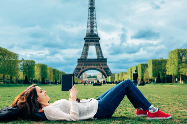 istock Woman resting and reading an e-book near the Eiffel tower 2199954013