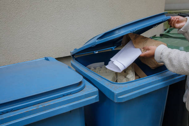 istock Woman throwing away paper waste to the special blue container 2199955668