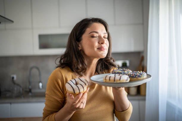 istock Cheerful woman enjoying donuts 2199961686