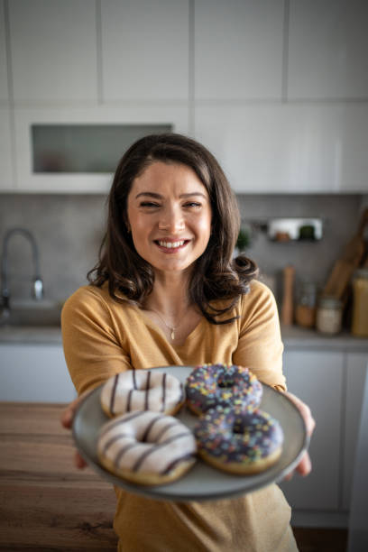 istock Cheerful woman enjoying donuts 2199961712