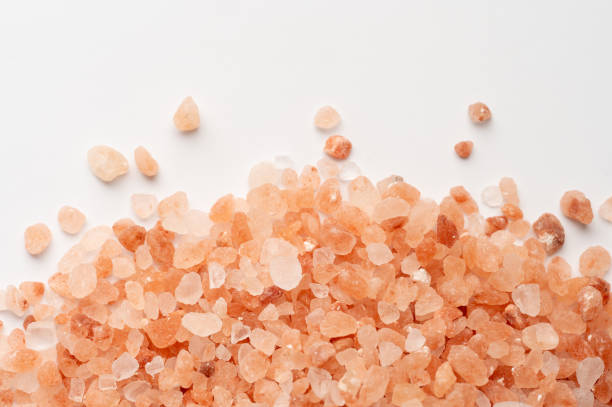 istock Scattered Himalayan pink salt crystals on white background 2199970529