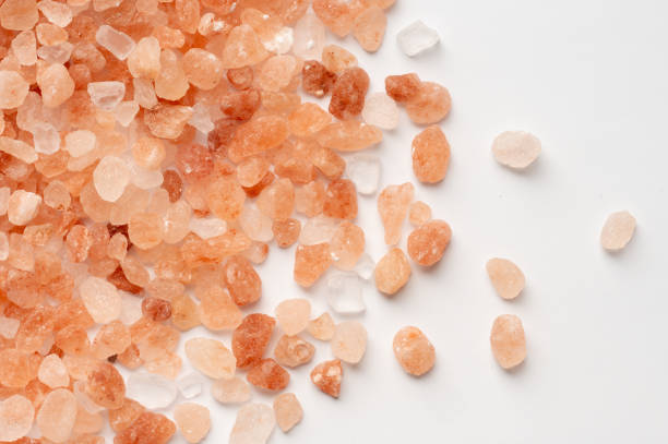 istock Scattered Himalayan pink salt crystals on white background 2199970541