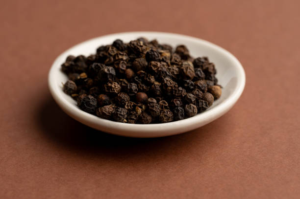 istock Top view of black peppercorns in white bowl 2199970657