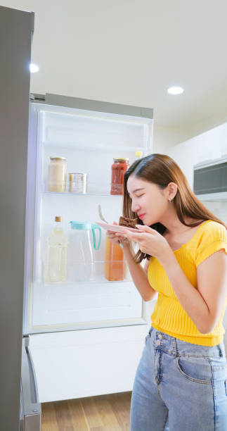 istock woman takes cake from refrigerator 2199971378