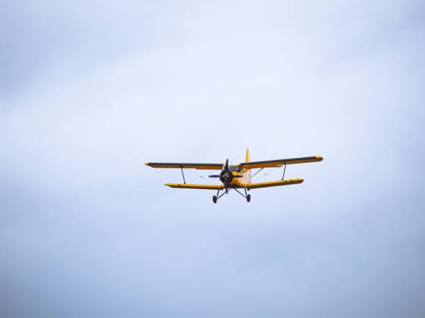 istock Yellow vintage biplane flying against cloudy sky 2199972170
