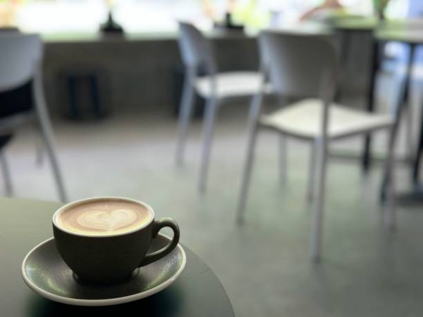 istock A beautiful latte art on a hot latte in a grey cup, with a black table and a cafe background. 2199972489