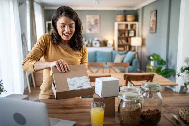 istock Excited young woman opening a package at home 2199972855