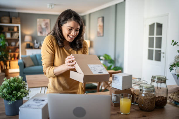 istock Excited young woman opening a package at home 2199972926