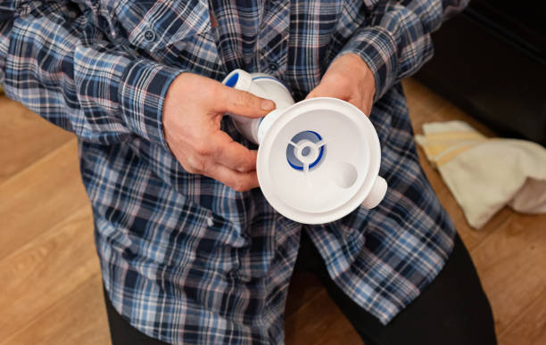 istock An elderly man focuses on assembling plumbing components for the kitchen and bathroom on a wooden floor. 2199982542