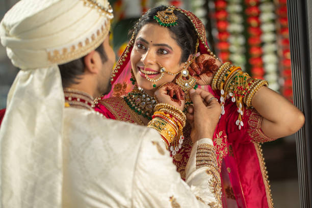 istock Happy bride showing her earring to groom in wedding ceremony 2199983589
