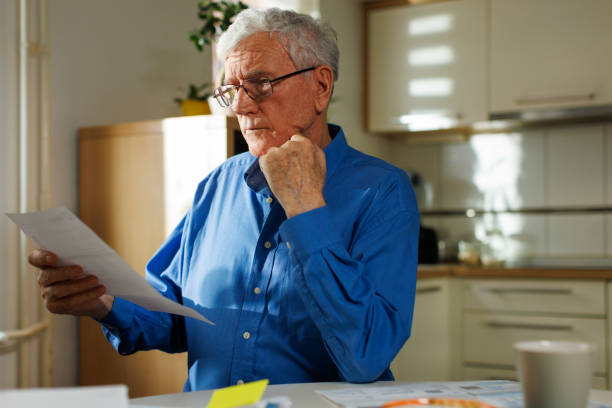 istock 77-Year-Old Man Reviewing a Financial Document with Hand on Chin 2199983777