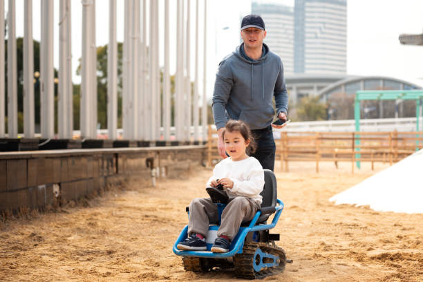istock Father learns his multiracial daughter how to drive toy car 2199986730