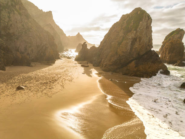 istock Scenic rocky beach with ocean waves at sunset 2199986953