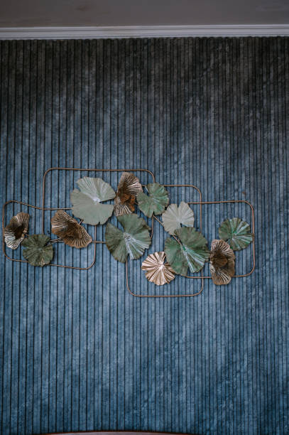Elegant metallic foliage against textured turquoise wall ornamentation