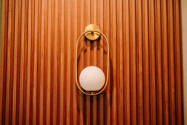 istock Elegant modern lighting fixture illuminating a textured wooden panel wall 2199987395