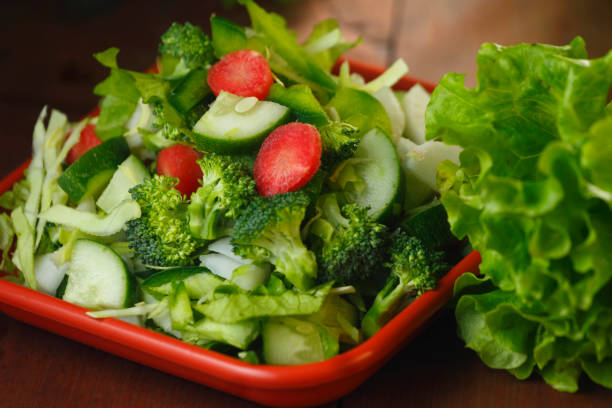 Salad with Tomatoes, Cucumber and Rocket on bright Background. Healthy Snack Idea. Close up.