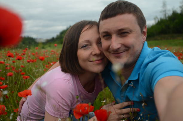 istock Young couple among blooming red poppies 2199988494