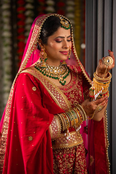 istock Bride in red dress looking at her bangles in wedding ceremony 2199990804