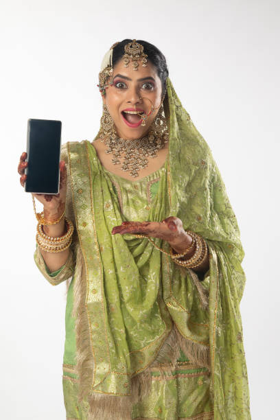 istock Surprised bride showing mobile phone on white background 2199991858