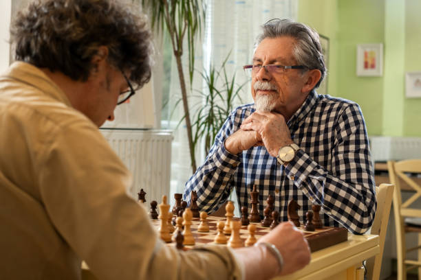 istock Two men playing chess in a cozy home 2199992164