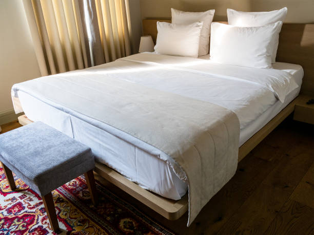 istock double bed with white linens in hotel room 2199992519