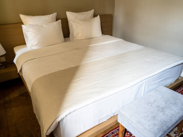istock double bed with white linens in small hotel room 2199992528