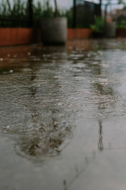 istock Rhythmic Raindrops Reflecting Serenity on a Concrete Surface Scene 2199993524