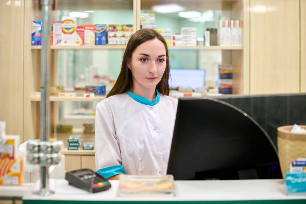 istock Young female pharmacist at counter in modern pharmacy setting 2199997383