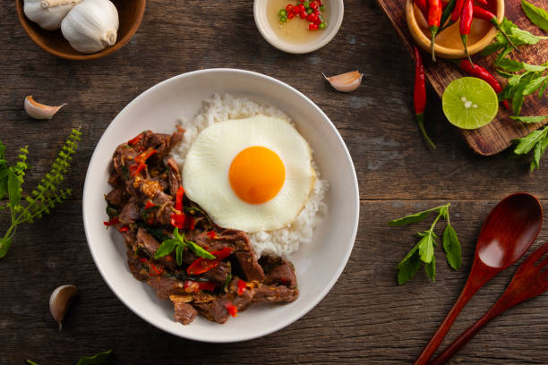 istock Stir fried sliced Beef with Holy Basil and Cooked Rice topped with fried egg in black plate. 2200000361