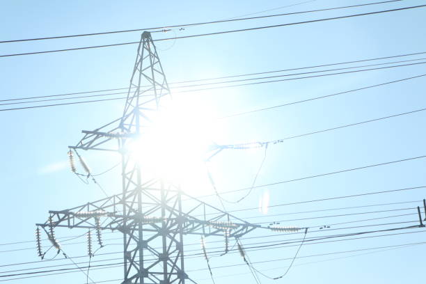 A tall power tower with high voltage lines shines in sunlight, symbolizing smooth energy flow through the grid