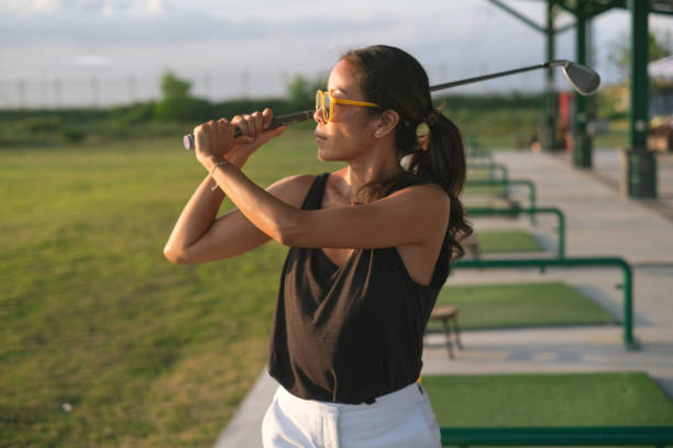 istock Focused Mature Asian Woman Practicing Golf at Driving Range 2200002347