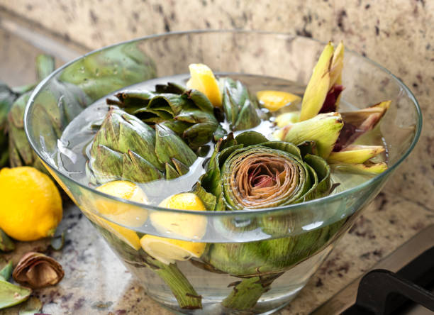 Fresh artichokesin bowl on kitchen table