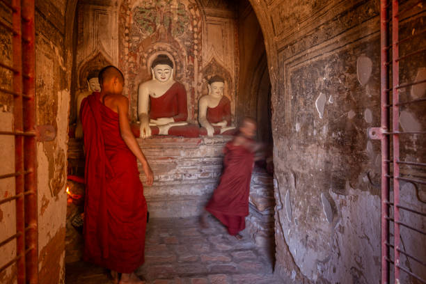 Two young monks praying in an ancient temple in bagan, myanmar
