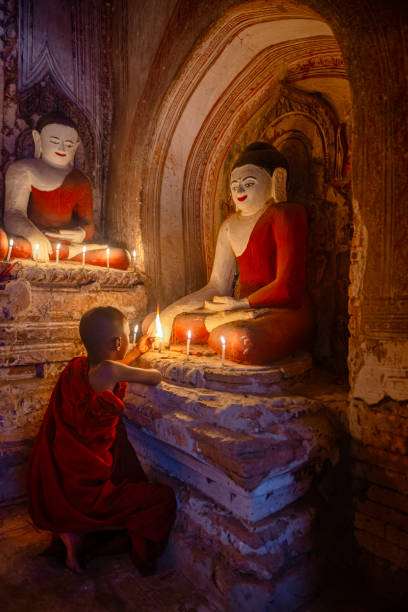 istock Young buddhist monk lighting candles at bagan temple in myanmar 2200005358