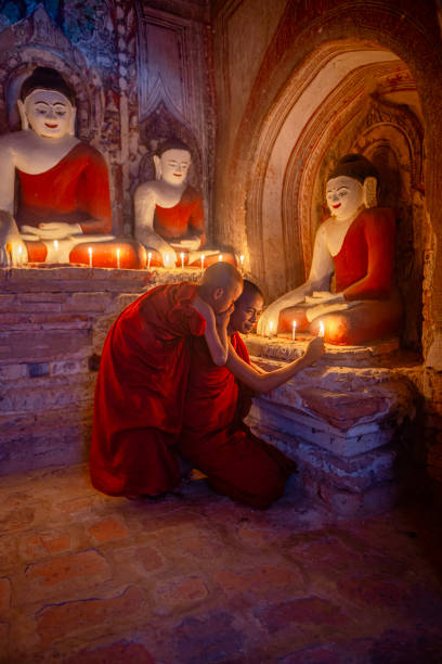 istock Young monks praying with candles at bagan temple in myanmar 2200005360