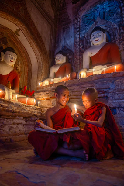 istock Young buddhist monks reading by candlelight in bagan temple 2200005568