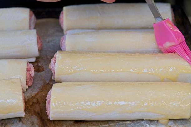 istock Use a pink silicone brush to evenly apply egg wash to the sausage roll while baking. 2200008880